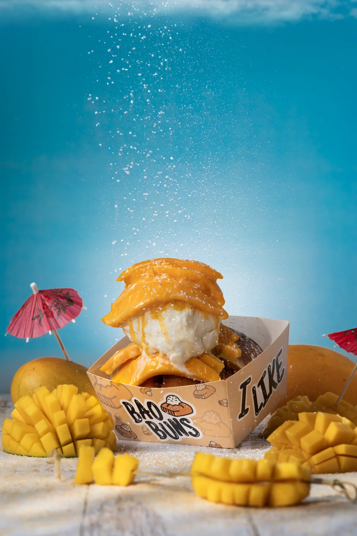 Bao Buns mango dessert with fruit on a blue backdrop